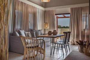 a living room with a table and chairs and a couch at Avithos Resort Hotel in Svoronata