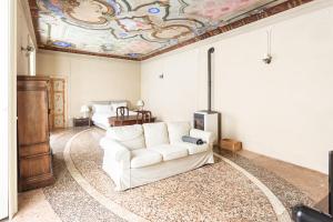 a living room with a white couch and a painted ceiling at Palazzo Mia by iCasamia in Castello Cabiaglio