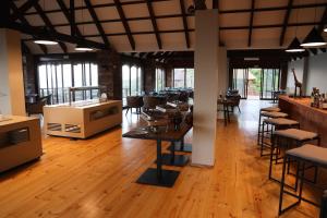 restauracja z drewnianymi podłogami, stołami i krzesłami w obiekcie Montebelo Milibangalala Bay Resort w mieście Maputo