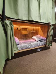 塞爾吉耶夫的住宿－Хостел Матрешка，配有窗帘的客房内的一张小双层床
