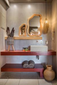 a bathroom with a red shelf and a mirror at Avithos Resort Hotel in Svoronata