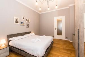 um quarto com uma cama grande e lençóis brancos em MM Pozzo Strada Terrace Apartment em Turim