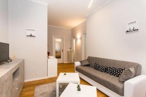- un salon avec un canapé et une télévision dans l'établissement MM Pozzo Strada Terrace Apartment, à Turin