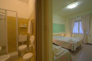 a bathroom with a bedroom with two beds and a shower at Hotel Savoia in Finale Ligure