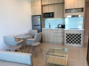 a small kitchen with a table and chairs in a room at City Garden Tower Condo by Som in Pattaya South
