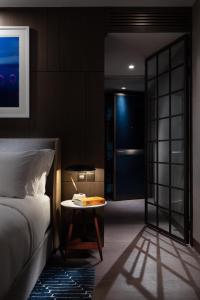 a room with a bed, table and a refrigerator at The Hari Hong Kong in Hong Kong