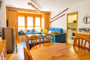 uma sala de estar com um sofá azul e uma mesa em La Marmota Suite apartamento rústico en Panticosa em Panticosa