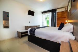 een slaapkamer met een groot bed en een raam bij Collection O Hotel Mango,Six Flags Hurricane Harbor Oaxtepec in Oaxtepec