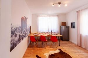 ein Esszimmer mit einem Tisch und roten Stühlen in der Unterkunft Modern & spacious apartment for up to 8 persons in Würzburg
