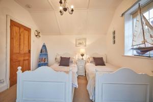 a bedroom with two beds and a boat on the wall at Host & Stay - The View Old Coastguard Cottage in Tynemouth