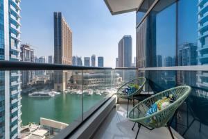 a balcony with two chairs and a view of a harbor at The Smart Concierge - Bay Central in Dubai