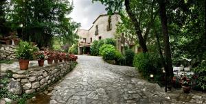 een stenen pad voor een gebouw met bloemen bij CAN MARLET MONTSENY Hotel Boutique in Montseny