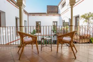 a balcony with two chairs and a table at Apartamentos Los Patios de la Judería in Córdoba