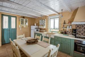 una cucina con armadi verdi e un tavolo con sedie di Villa Vigla a Samonás