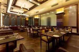 a restaurant with tables and chairs in a room at Grand Hotel Mumbai - Ballard Estate, Fort in Mumbai