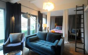 a living room with a blue couch and a bed at The Cabin in Cheltenham