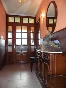 a bathroom with a wooden door and a mirror at Casa Gayol in El Franco +75 photos