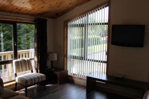 a living room with a large window and a television at Beechtree Chalet in Warrenpoint