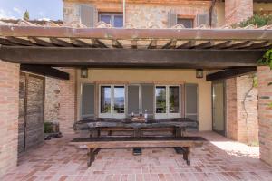 eine Außenterrasse mit einem Holztisch und einem Gebäude in der Unterkunft Villa Tinaia - Homelike Villas in Molinelli
