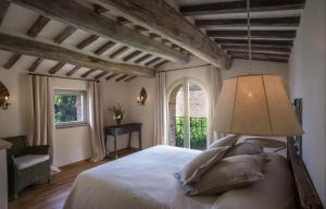 ein Schlafzimmer mit einem Bett mit einer Lampe und einem Fenster in der Unterkunft Villa Tinaia - Homelike Villas in Molinelli