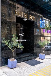 a hotel lobby with two trees in front of it at ROY Hotel in Athens