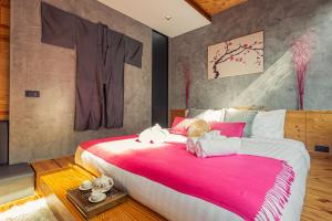 Un dormitorio con una cama grande con dos animales de peluche. en Cozy design studio near Nai Harn beach en Nai Harn Beach