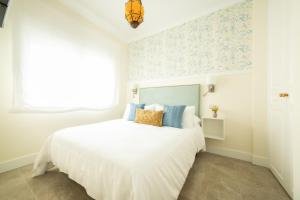 a bedroom with a white bed and a window at Apartamentos San Francisco - Centrico in Mota del Cuervo