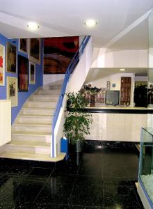 un escalier dans un bâtiment aux murs bleus et blancs dans l'établissement ROY Hotel, à Athènes