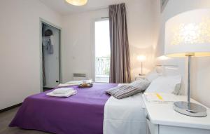 um quarto de hotel com uma cama roxa e uma janela em Terres de France - Résidence Côté Provence em Gréoux-les-Bains