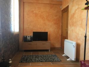 a living room with a tv on a dresser at Acogedor estudio junto a pista in Sierra Nevada