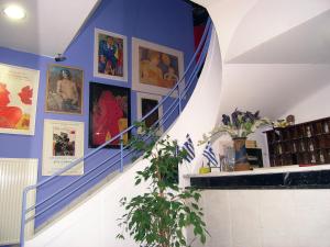 a blue and white staircase with pictures on the wall at ROY Hotel in Athens