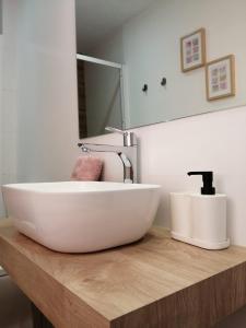 La salle de bains est pourvue d'un lavabo blanc et d'un miroir. dans l'établissement Via ca´ls Avis, à Campredó