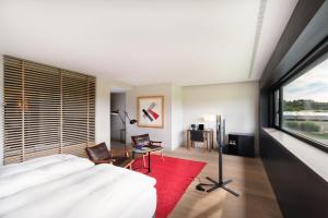 um quarto com uma cama e uma grande janela em Eurostars Pamplona em Pamplona
