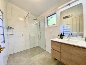 uma casa de banho com um chuveiro, um lavatório e um espelho. em Brigadoon Cottages em Haunted Hills