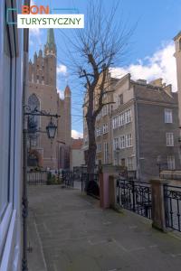 a city street with buildings and a church at Happy Stay Mariacka Apartment II in Gdańsk
