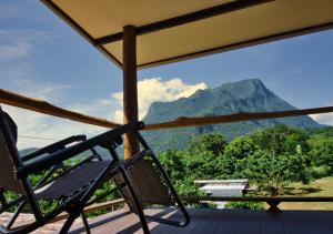a chair on a deck with a view of a mountain at Cozycomo Chiang Dao - Pha Mok in Amphoe Chiang Dao