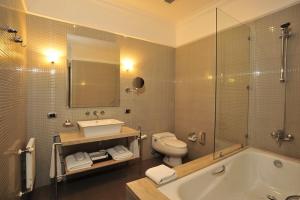 y baño con bañera, aseo y lavamanos. en Hotel Casa Higueras en Valparaíso