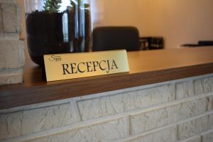 a sign on a counter that reads sing recuerda at Sepia Restauracja & Noclegi in Jasło