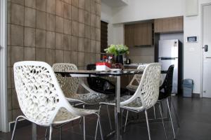 a dining room table with white chairs in a kitchen at Sentrio Suites Desa Pandan in Kuala Lumpur