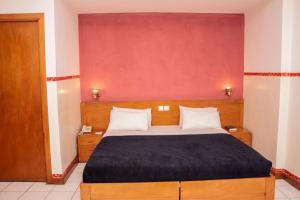 卢本巴希Park Hotel的一间卧室设有一张床和红色的墙壁 更多37张照片