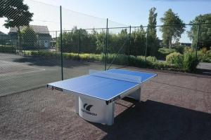 a ping pong table sitting on a tennis court at Dahlia 107 - zonnig en volledig uitgerust appartement in De Haan