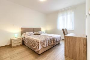 Schlafzimmer mit einem Bett, einer Kommode und einem Schreibtisch in der Unterkunft Luxury villa Banjole with private pool 200m from the beach - WiiBuk in Banjole + 27 Fotos