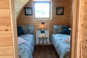 Un ou plusieurs lits dans un hébergement de l'établissement Tollymore Luxury Log Cabin