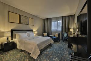 a hotel room with a bed and a television at Iris Boutique Granada in Riyadh