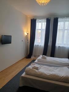 Apartamenty Rynek في ليزايسك: غرفة فندقية بسريرين وتلفزيون