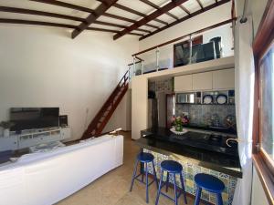 eine Küche mit einer Theke und Hockern in einem Zimmer in der Unterkunft Taiba Beach Resort 01 Apto 2 quartos in São Gonçalo do Amarante