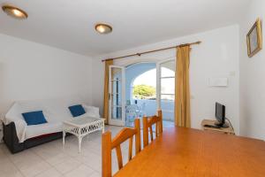 a living room with a bed and a dining room table at Maluz in Arenal d'en Castell