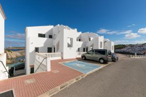 a car parked in front of a white building at Maluz in Arenal d'en Castell