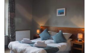 a bedroom with a bed with towels on it at The Wellwood in Amble