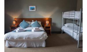 a bedroom with a bed with two bunk beds at The Wellwood in Amble
